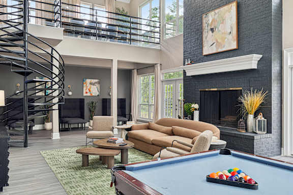 A living room with a pool table and a fireplace.