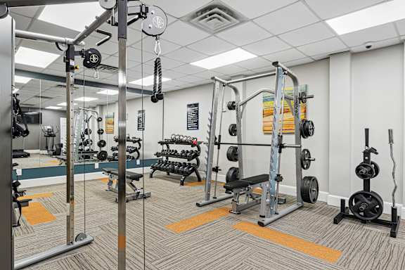 A gym with a variety of equipment including weights and weight machines.