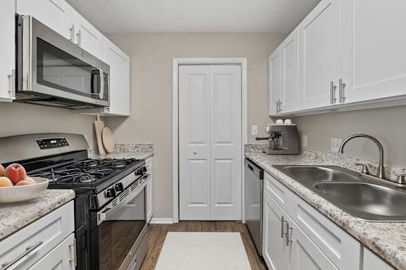 Updated kitchen with white shaker cabinets, stainless steel appliances and ample counter space