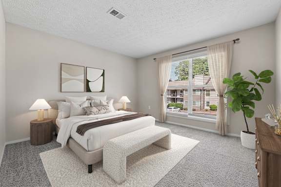 Primary bedroom with large windows, plush carpeting and abundant natural light