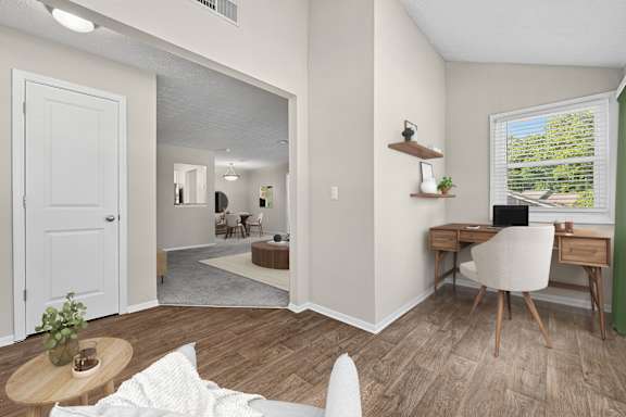 Sunroom with wood flooring, workspace and open connection to living area