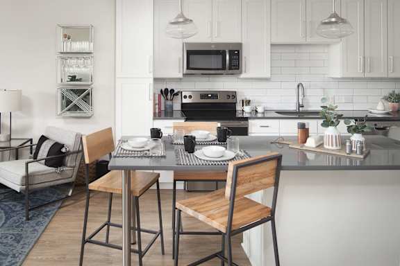 Open kitchen with breakfast bar and pendant lighting at Pointe at Research Park Apartments, North Carolina, 28262