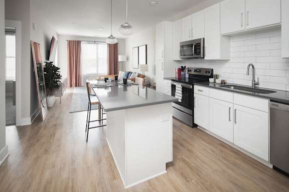 Contemporary kitchen with island seating and stainless appliances at Pointe at Research Park Apartments, Charlotte, NC