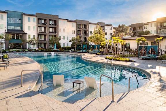 A swimming pool surrounded by apartment buildings.
