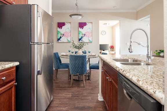a kitchen and dining room with stainless steel appliances and granite counter tops