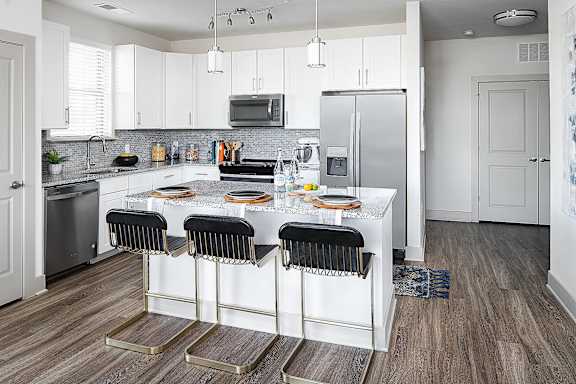 a kitchen with a center island and a refrigerator