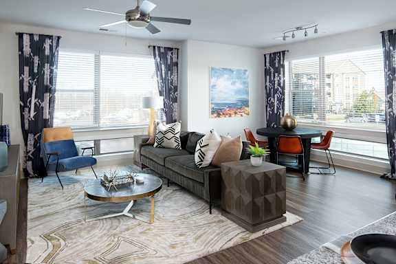 A living room with a grey sofa, a coffee table, and a painting on the wall.