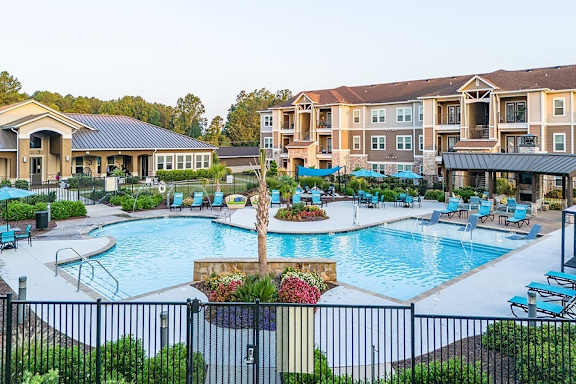 an outdoor swimming pool with apartments in the background
