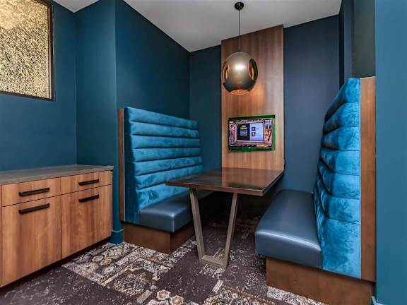 Booth seating with an individual TV in the lounge at Berewick Pointe Apartments in Charlotte, NC.