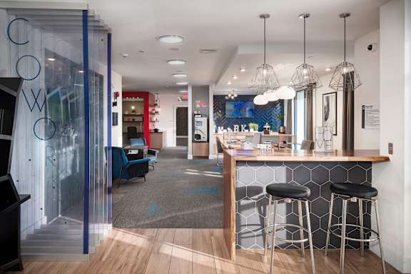 A modern bar area with a wooden counter and stools.