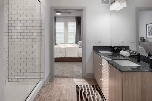 A bathroom with a walk-in shower and a vanity with a mirror.