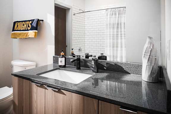 A bathroom with a sink, toilet, and a shower curtain.
