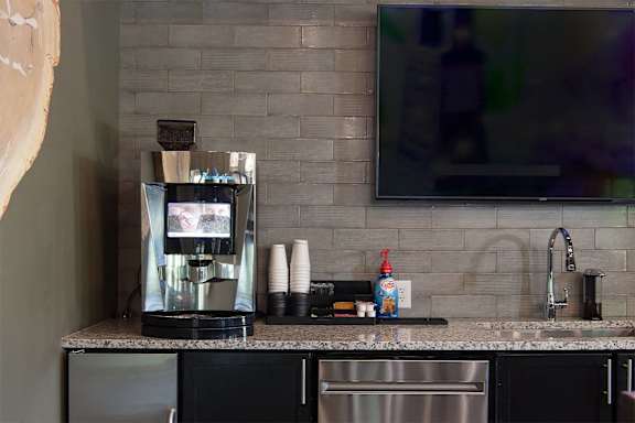Kitchenette with coffee maker and sink under wall mounted tv at TRAILSIDE VERDAE Apartments, GREENVILLE, 29607