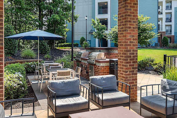 Outdoor kitchen with built in grill and lounge seating at TRAILSIDE VERDAE Apartments, GREENVILLE, 29607