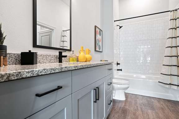 A bathroom with a white toilet and a white bathtub.