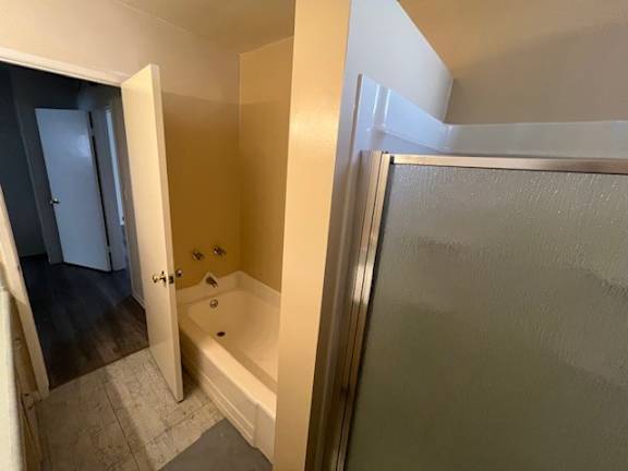 A bathroom with a tub and a shower.