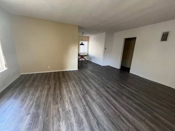 A room with wooden flooring and white walls.