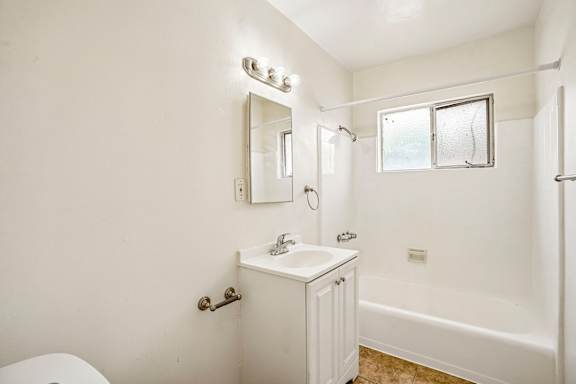 A white bathroom with a toilet, sink, and bathtub.