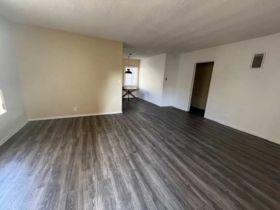 A room with wooden flooring and white walls.