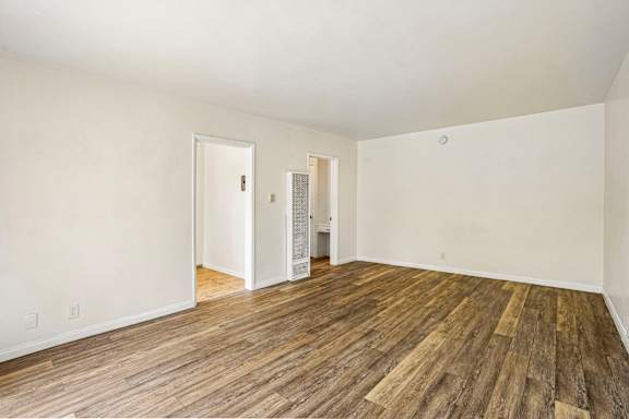 A room with wooden floors and two doors.
