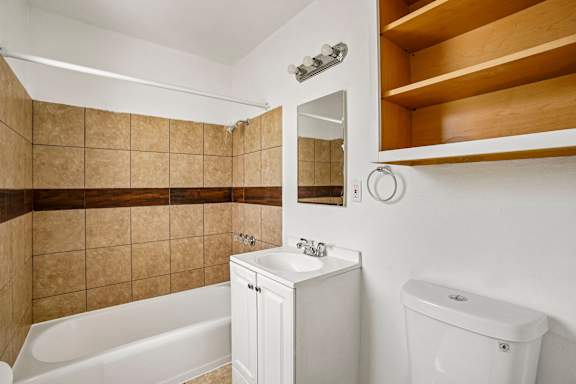 A white bathroom with a tub, sink, and toilet.