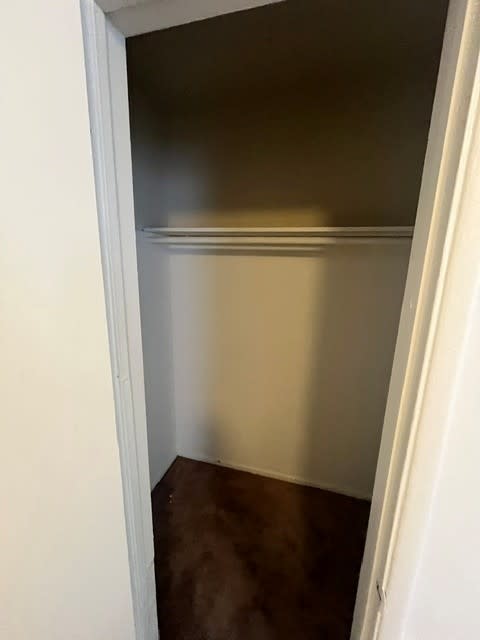 A white door is open to a dark room.