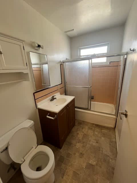 A bathroom with a toilet, sink, and shower.