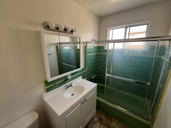 A bathroom with a sink, mirror, and shower.