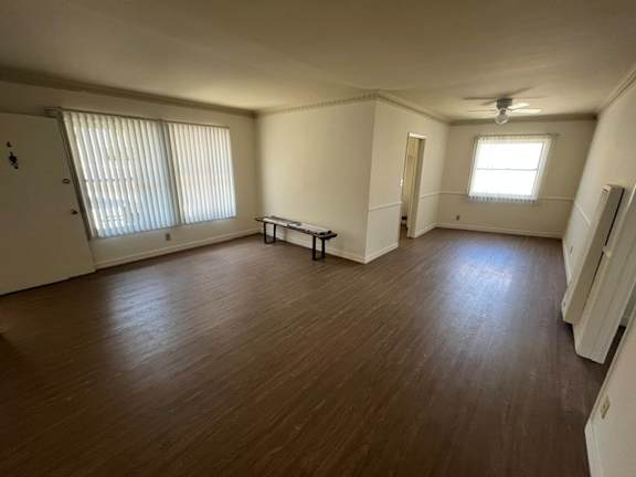 A room with wooden flooring and a bench in the middle.