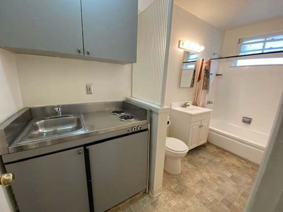A small, clean, and well-organized kitchen with a sink, stove, and refrigerator.