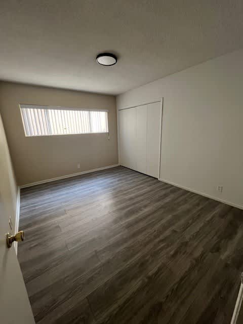 A room with a wooden floor and a window.