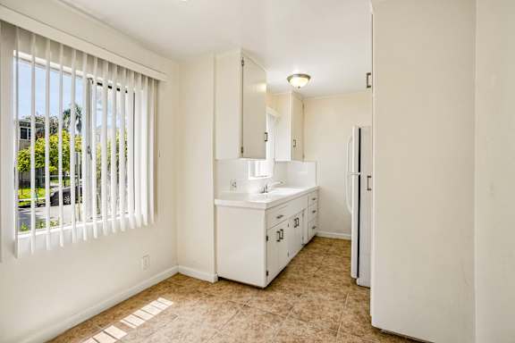 A white kitchen with a window and a sink.