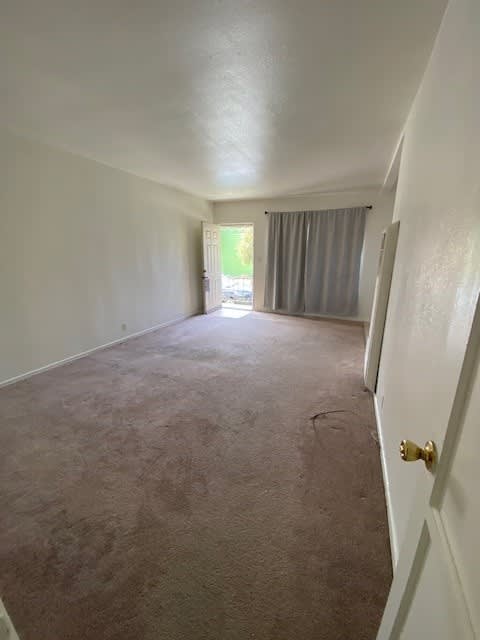A long hallway with a carpeted floor and white walls.
