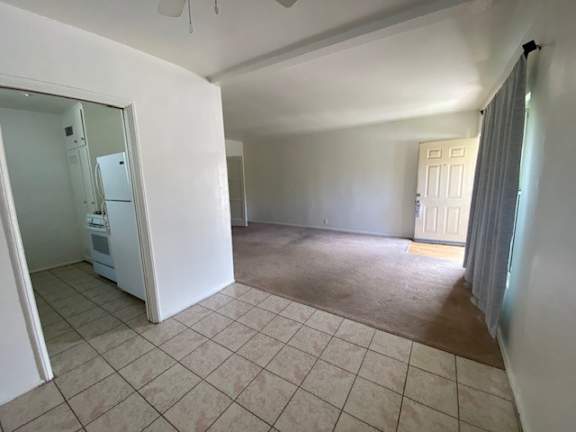 A room with a tiled floor and a white door.