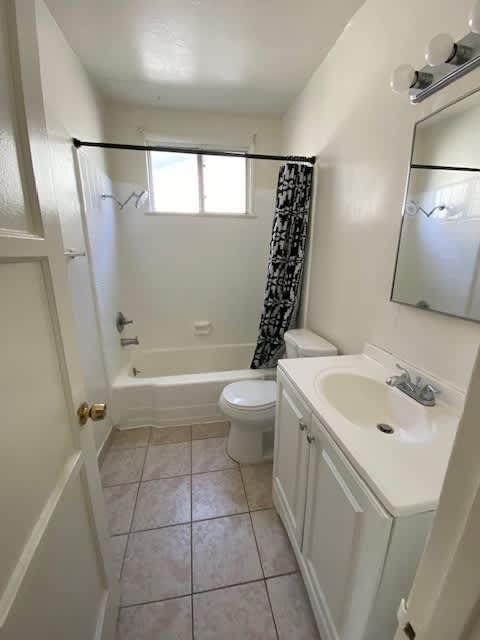 A white bathroom with a toilet, sink, and bathtub.