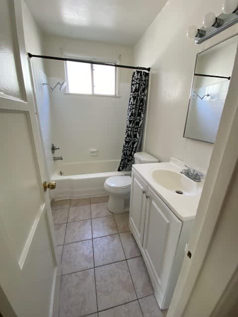 A white bathroom with a toilet, sink, and bathtub.
