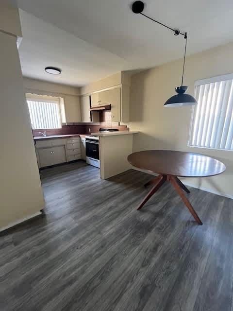 A kitchen with a table and a hanging light.