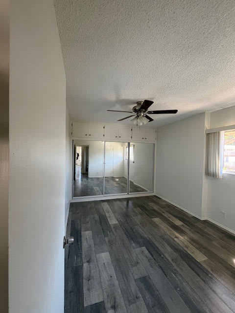 A room with a ceiling fan and a wooden floor.