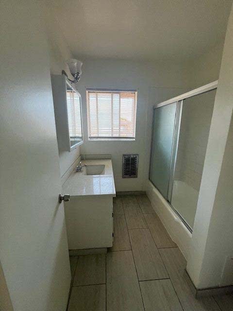 A small bathroom with a sink and a window.