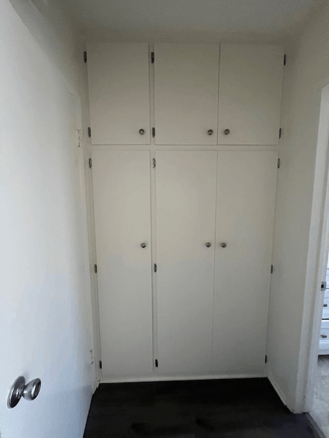 A white door with a handle and a white wall.