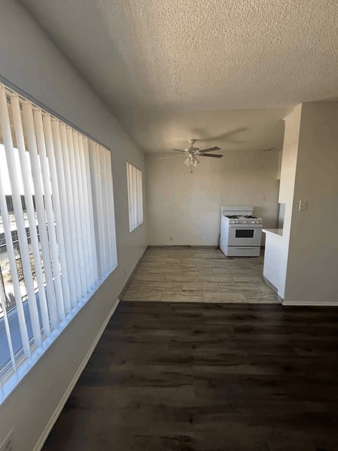 A room with a ceiling fan and a microwave.