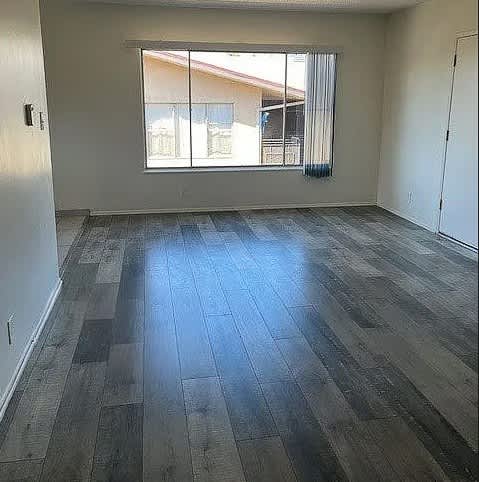 A room with a large window and wooden flooring.