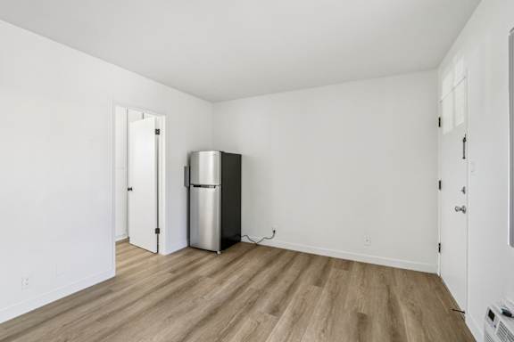 A kitchen with a fridge and a door.