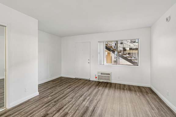 A room with a wooden floor and a picture on the wall.