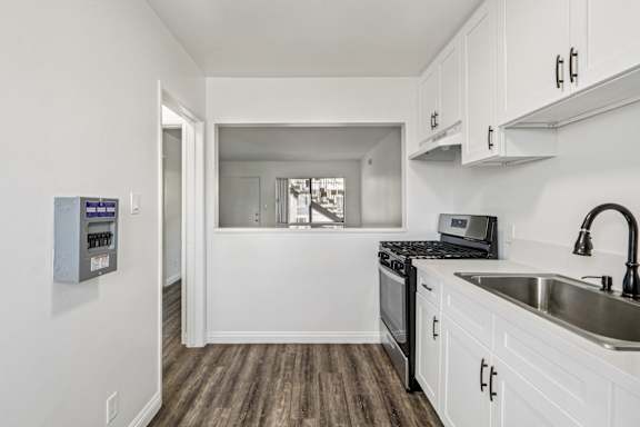 A kitchen with white cabinets and a black stove top oven.