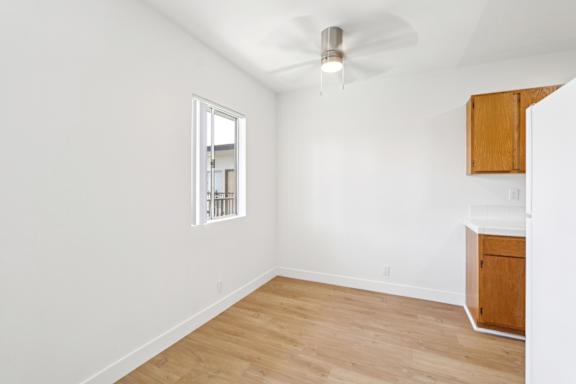 A room with a ceiling fan and a window.