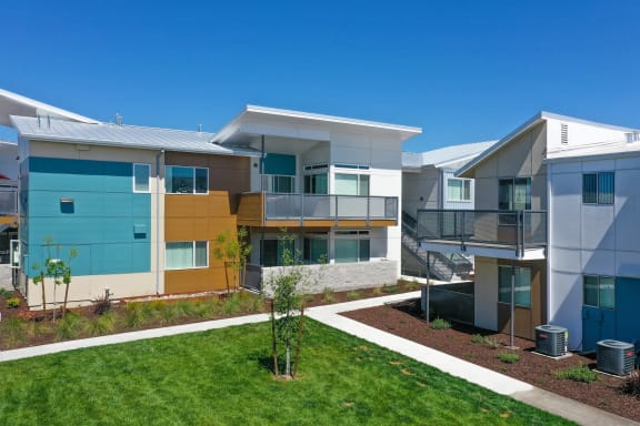 Apartment Exterior with Walking Path, Grass, Wood Chip Floor, Blue Apartment Exterior at Addison Ranch Apartments, Petaluma, California