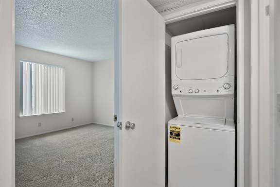 A white fridge is in a room with a door open.