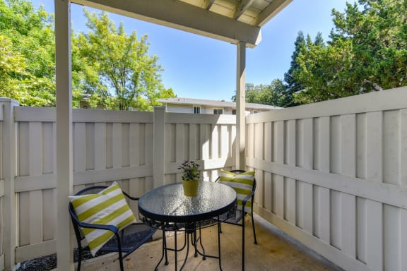 First floor outdoor patio with a bistro table and two chairs at The Renaissance Apartments, Citrus Heights, CA