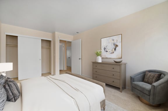 a bedroom with a bed and a chair and a dresser